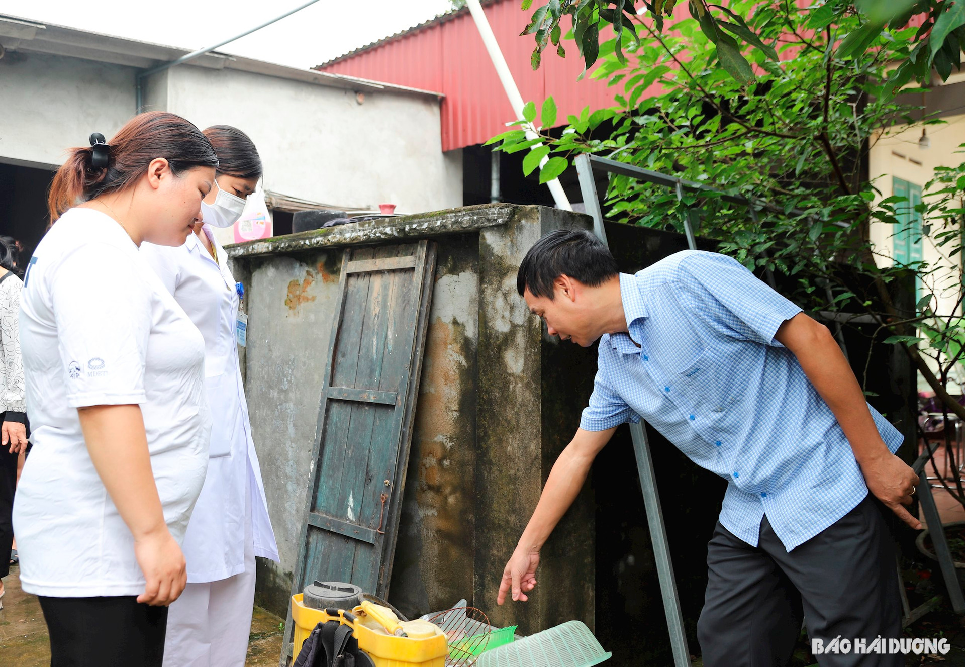 Lãnh đạo Trung tâm Kiểm soát bệnh tật và cán bộ y tế truyền thông tư vấn cho người dân về biện pháp loại trừ lăng quăng