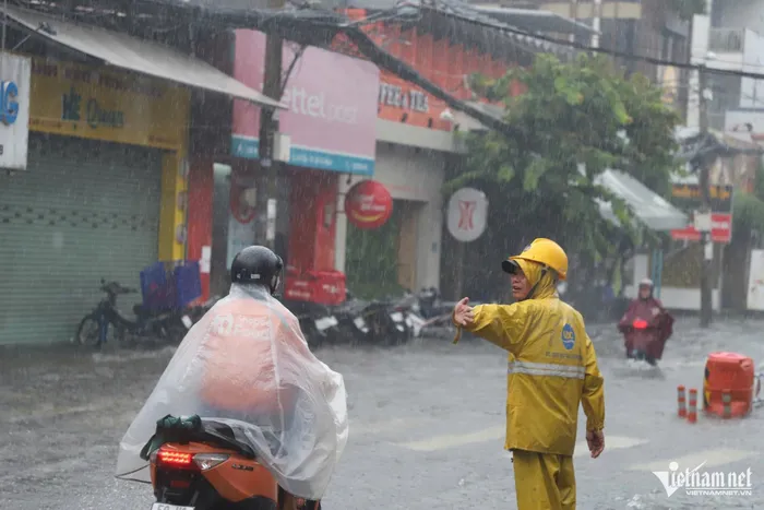 Đến 12h trưa, đường Nguyễn Văn Khối (quận Gò Vấp) vẫn ngập như sông. Công ty thoát nước đô thị TPHCM điều động 5 nhân viên túc trực để đặt cảnh báo, hỗ trợ và hướng dẫn người dân chọn lộ trình di chuyển thích hợp.