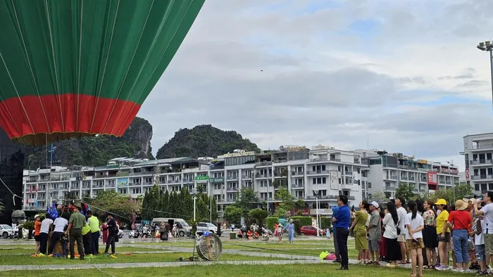 Người dân xếp hàng để chờ được trải nghiệm bay treo khinh khí cầu miễn phí. Ảnh: Tiến Dũng.