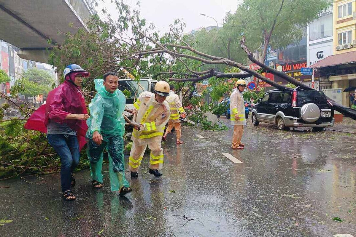 Cảnh sát giao thông hỗ trợ người dân gặp nạn do cây đổ trên đường Hồ Tùng Mậu (quận Cầu Giấy, Hà Nội) chiều 7/9.