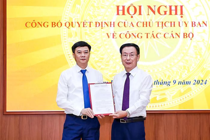 Chủ tịch UBND tỉnh Phạm Đình Nghị trao quyết định và tặng hoa ông Nguyễn Xuân Hồng, Giám đốc Sở Giáo dục và Đào tạo. Ảnh: Trọng Tùng