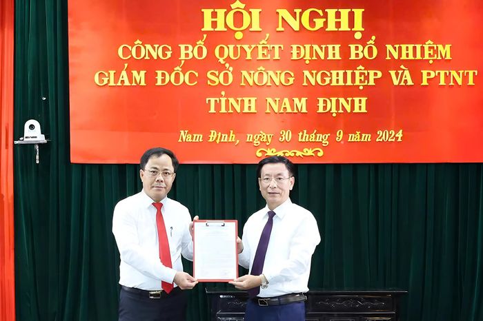 Chủ tịch UBND tỉnh Phạm Đình Nghị trao quyết định và tặng hoa chúc mừng ông Nguyễn Sinh Tiến, Giám đốc Sở Nông nghiệp và Phát triển Nông thôn. Ảnh: Trọng Tùng